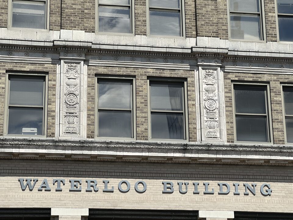 The carved WATERLOO BUILDING sign and limestone detailing on the facade at 531 Commercial Street, Waterloo, Iowa